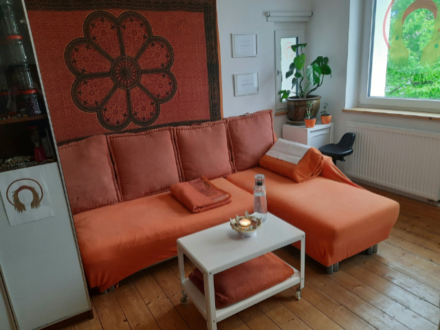 DREADERikes orangenes Sofa mit großen Kissen.